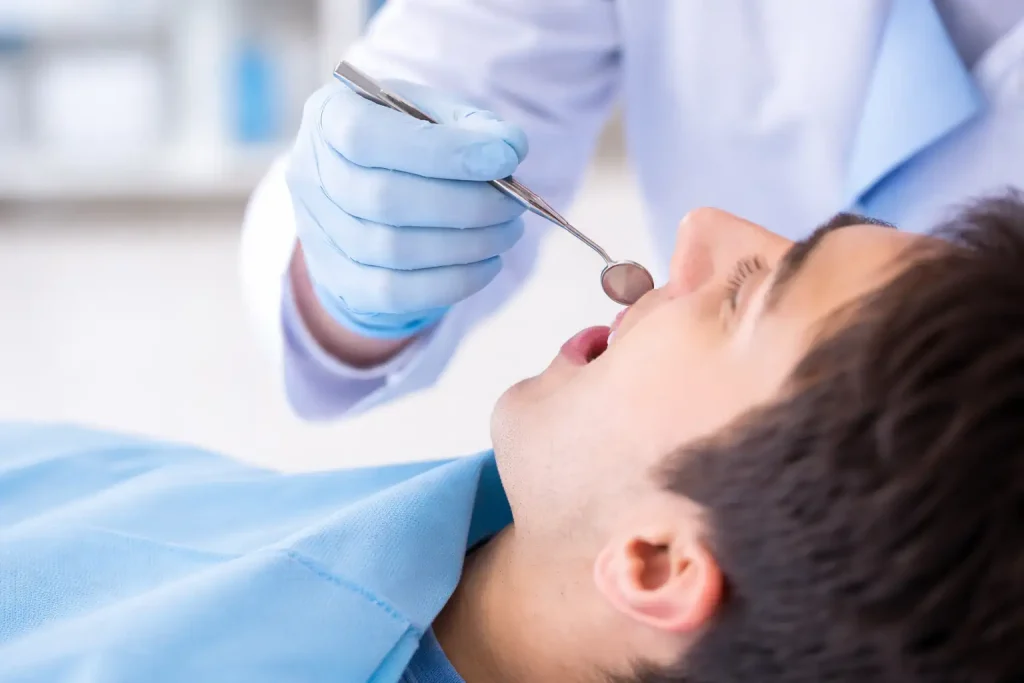 Dentiste examinant une dent avec un pansement dentaire provisoire en cabinet