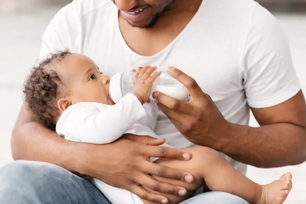 : Papa donnant un biberon de lait à un bébé de 2 mois